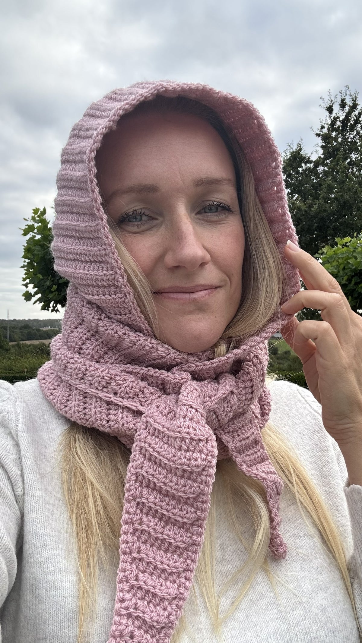 Close-up of a pink crochet Sophie Hood showing ribbed texture around the hood and scarf