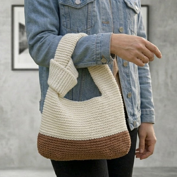 Digital PDF crochet pattern for a modern knotted handbag. Make a stylish crochet bag with a two-tone body, sturdy handle and knot detail. US terms.
