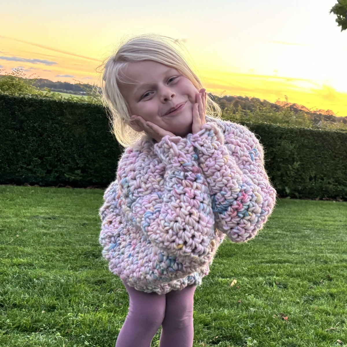 Three-view collage of a girl wearing the pastel Yarnicorn crochet sweater, showing the back, angled front and oversized sleeve details.