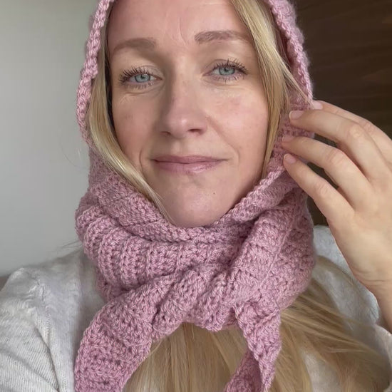 Pink ribbed crochet Sophie Hood worn with the scarf wrapped around the neck